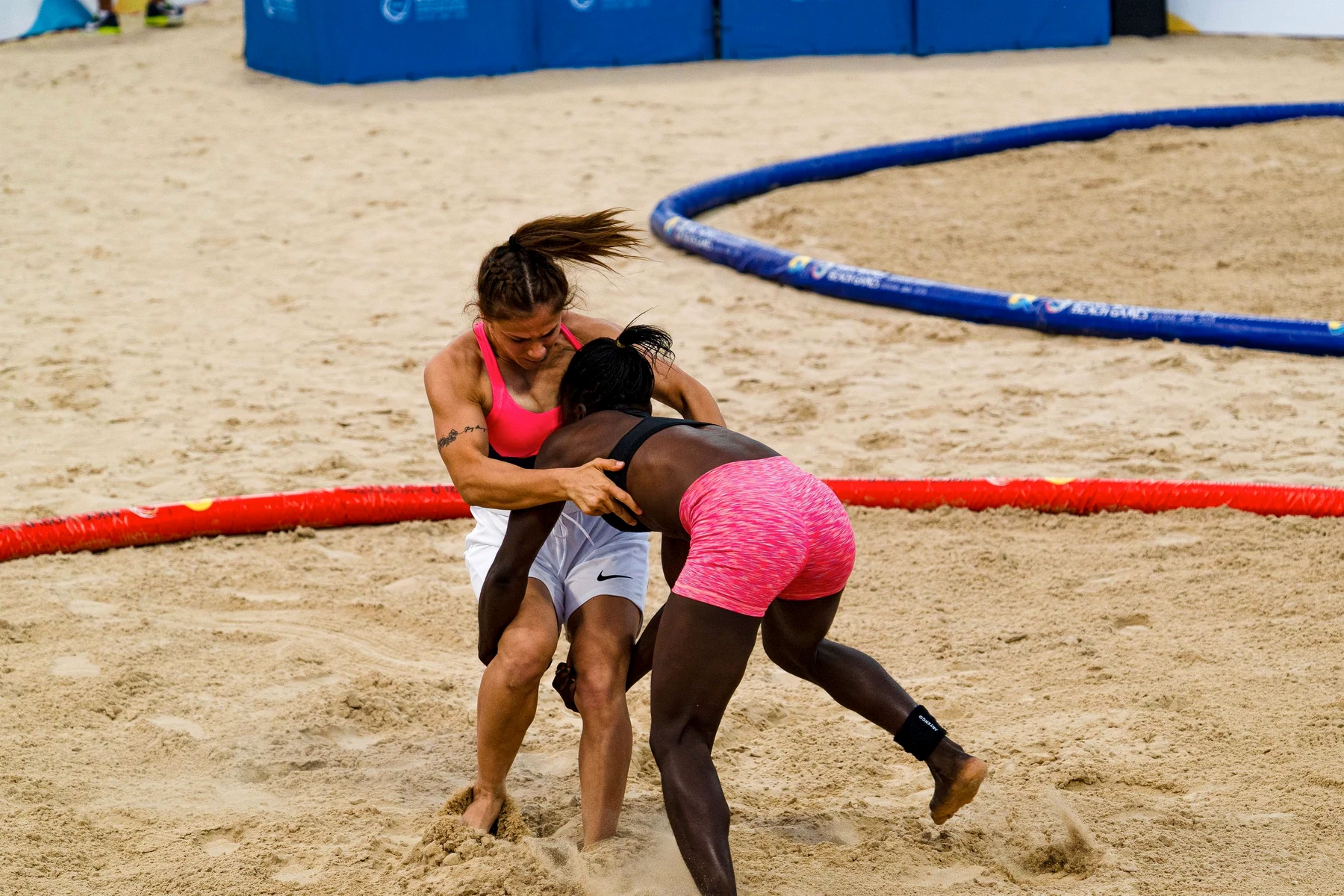 Women competing in a wrestling clinic environment